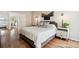 Stylish bedroom featuring hardwood floors, a cozy bed, and decorative lighting fixtures at 7035 S Flower Ct, Littleton, CO 80128