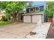 Two-story home featuring blue siding, brick accents, a two-car garage, and a well-maintained front yard at 7035 S Flower Ct, Littleton, CO 80128