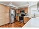 Kitchen with stainless steel refrigerator, oven, microwave, light wood cabinets, and light countertops at 7035 S Flower Ct, Littleton, CO 80128
