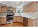 Kitchen with stainless steel appliances, light wood cabinets, light countertops, and hardwood floors at 7035 S Flower Ct, Littleton, CO 80128