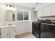 Functional laundry room with washer, dryer, storage cabinets, sink, and a window at 7035 S Flower Ct, Littleton, CO 80128