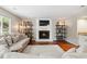 Bright living room features a fireplace, wood floors, and decorative shelving at 7035 S Flower Ct, Littleton, CO 80128