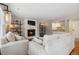 Inviting living room features a cozy fireplace, built-in shelving, and a convenient wet bar for entertaining at 7035 S Flower Ct, Littleton, CO 80128