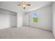 This bedroom features neutral carpeting, a ceiling fan, a window, and a closet at 8603 Barberry Pl, Parker, CO 80134