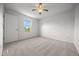 This bedroom features neutral carpeting, a ceiling fan, a window, and a door at 8603 Barberry Pl, Parker, CO 80134
