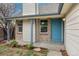 Inviting front porch with a colorful door, brick accents, and manicured landscaping at 8603 Barberry Pl, Parker, CO 80134