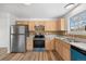 Bright kitchen with stainless steel refrigerator, wooden cabinets, and modern appliances at 8603 Barberry Pl, Parker, CO 80134