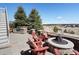 Backyard featuring a brick fire pit, grilling station, seating, and mature trees at 23713 E Eads Dr, Aurora, CO 80016