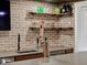 Close-up of basement bar with brick backsplash, beer tap, sink, and ample counter space at 23713 E Eads Dr, Aurora, CO 80016