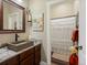 Stylish bathroom with a stone sink, elegant fixtures, and a separate shower featuring a decorative curtain at 23713 E Eads Dr, Aurora, CO 80016
