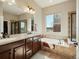 Luxurious bathroom features dual sinks, a soaking tub, and a separate shower with tiled walls at 23713 E Eads Dr, Aurora, CO 80016
