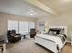 Bright bedroom features a white bed, sitting area, and large windows for natural light at 23713 E Eads Dr, Aurora, CO 80016