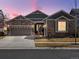 Charming single-Gathering home with stone accents, a two-car garage, and a well-maintained lawn at dusk at 23713 E Eads Dr, Aurora, CO 80016