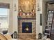 Cozy stone fireplace with decorative mantel, large clock, and accent lighting creates an inviting atmosphere at 23713 E Eads Dr, Aurora, CO 80016