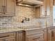 Elegant kitchen showcasing granite countertops, a brick backsplash, and a sleek cooktop for culinary enthusiasts at 23713 E Eads Dr, Aurora, CO 80016