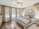 Serene main bedroom with large windows, wood floors, and a comfortable bed with stylish bedding at 23713 E Eads Dr, Aurora, CO 80016