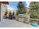 Backyard with a built-in outdoor kitchen, dining area, and beautifully paved patio at 23713 E Eads Dr, Aurora, CO 80016