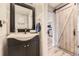 Stylish bathroom with a modern vanity, mirror, and a barn door leading to another room at 5316 S Rome St, Aurora, CO 80015