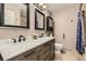Bathroom featuring dual sinks, granite countertops, new faucets, and tiled floors at 5316 S Rome St, Aurora, CO 80015