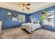 Comfortable bedroom with a ceiling fan, carpeted floor, natural light, and unique decor at 5316 S Rome St, Aurora, CO 80015
