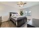 Cozy bedroom with a dark wood bed, ceiling fan, a large window, and neutral carpet at 5316 S Rome St, Aurora, CO 80015