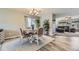 Dining area featuring a chandelier, four chairs, and hardwood floors, open to the living room at 5316 S Rome St, Aurora, CO 80015