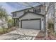 Two-story gray home featuring an attached two-car garage, lush lawn, and mature landscaping at 5316 S Rome St, Aurora, CO 80015