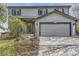 Charming gray two-story home with attached garage and manicured front yard is ideal for Gathering living at 5316 S Rome St, Aurora, CO 80015