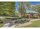A picturesque gazebo with red posts and a green roof, surrounded by lush landscaping and walking paths at 5316 S Rome St, Aurora, CO 80015