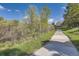 Community walking path with lush foliage and a view of nearby townhomes at 5316 S Rome St, Aurora, CO 80015