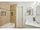 Bathroom showcasing a tiled tub, shower, modern vanity, and wall mirror at 3685 W Union Ave, Denver, CO 80236