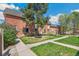 Brick townhomes with manicured lawn and walkways, complemented by mature trees and lilac bushes at 3685 W Union Ave, Denver, CO 80236