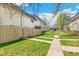 Exterior shot shows a fenced backyard with a small landscaped area and sidewalks to parking at 3685 W Union Ave, Denver, CO 80236