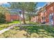 Exterior view of brick townhomes with green space, mature trees and walkways. A comfortable neighborhood at 3685 W Union Ave, Denver, CO 80236