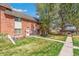 Exterior view of brick townhomes featuring lawns, walkways, and mature trees at 3685 W Union Ave, Denver, CO 80236