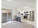 Eat-in kitchen with stainless appliances and white cabinets, flowing into living area at 3685 W Union Ave, Denver, CO 80236