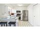 Bright eat-in kitchen with stainless appliances, white cabinetry, and counter seating at 3685 W Union Ave, Denver, CO 80236