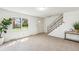 Bright living room showcasing a staircase, large window, and neutral carpeting at 3685 W Union Ave, Denver, CO 80236