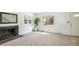 Living room showcasing a brick fireplace, large window, and neutral carpeting at 3685 W Union Ave, Denver, CO 80236