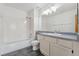 Bright bathroom features a shower-tub combo, white cabinets, and a large mirror at 7313 W 98Th Pl, Broomfield, CO 80021