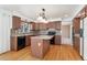 The kitchen features a central island, brown cabinets, and hardwood floors at 7313 W 98Th Pl, Broomfield, CO 80021
