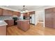 Open kitchen with wood flooring, an island with seating, black appliances, and decorative backsplash at 7313 W 98Th Pl, Broomfield, CO 80021