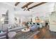 Open-concept living room and kitchen boasts wood beams, island seating, and modern finishes at 5943 S Olive Cir, Centennial, CO 80111