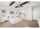 Main bedroom showcasing tray ceiling, exposed beams, and ensuite bath with a soaking tub at 5943 S Olive Cir, Centennial, CO 80111
