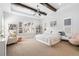 Bright main bedroom with tray ceilings, exposed beams, neutral decor, and large windows at 5943 S Olive Cir, Centennial, CO 80111