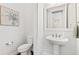 Stylish powder room with pedestal sink, modern fixtures, and elegant wall decor at 5943 S Olive Cir, Centennial, CO 80111