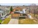 Aerial view of a tan two-story house with a two-car garage and landscaped front yard at 18736 E Powers Pl, Aurora, CO 80015