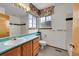 Bathroom featuring a turquoise countertop, tiled walls, and a window for natural light at 18736 E Powers Pl, Aurora, CO 80015