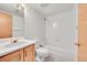 Bright bathroom with single sink vanity and shower/tub combo with tile surround at 18736 E Powers Pl, Aurora, CO 80015