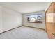 Bright bedroom with neutral carpet and a large window offering a view of the neighborhood at 18736 E Powers Pl, Aurora, CO 80015